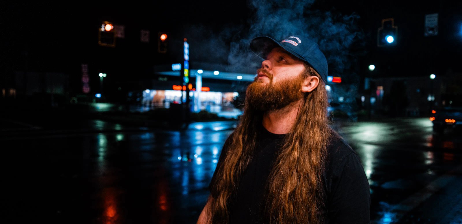 Jimmy Clepper standing on a rain-lit street at night